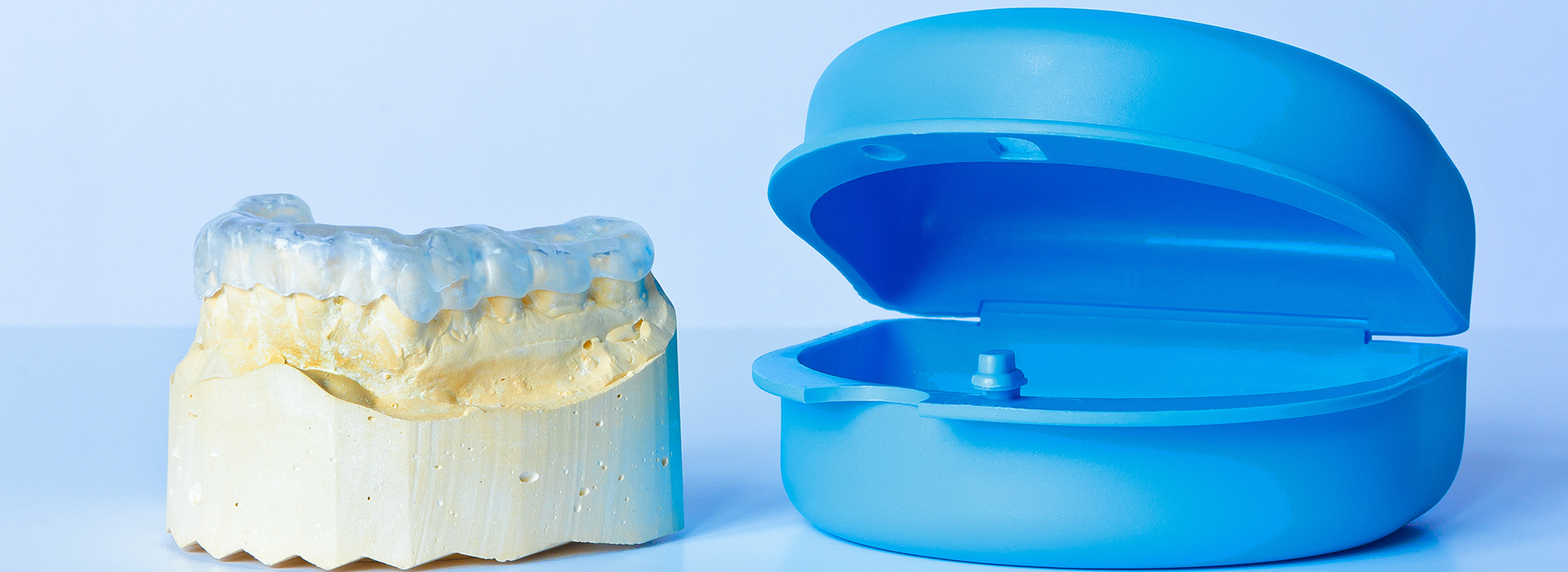 The image displays two dental implants, one visible with its circular base and the other obscured behind them, against a white background.